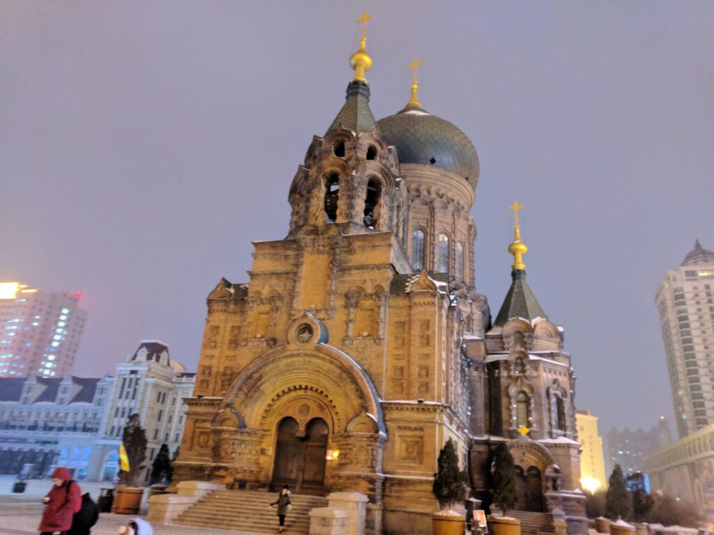 Saint Sophia Cathedral facade with green onion dome illuminated at winter twilight in Harbin