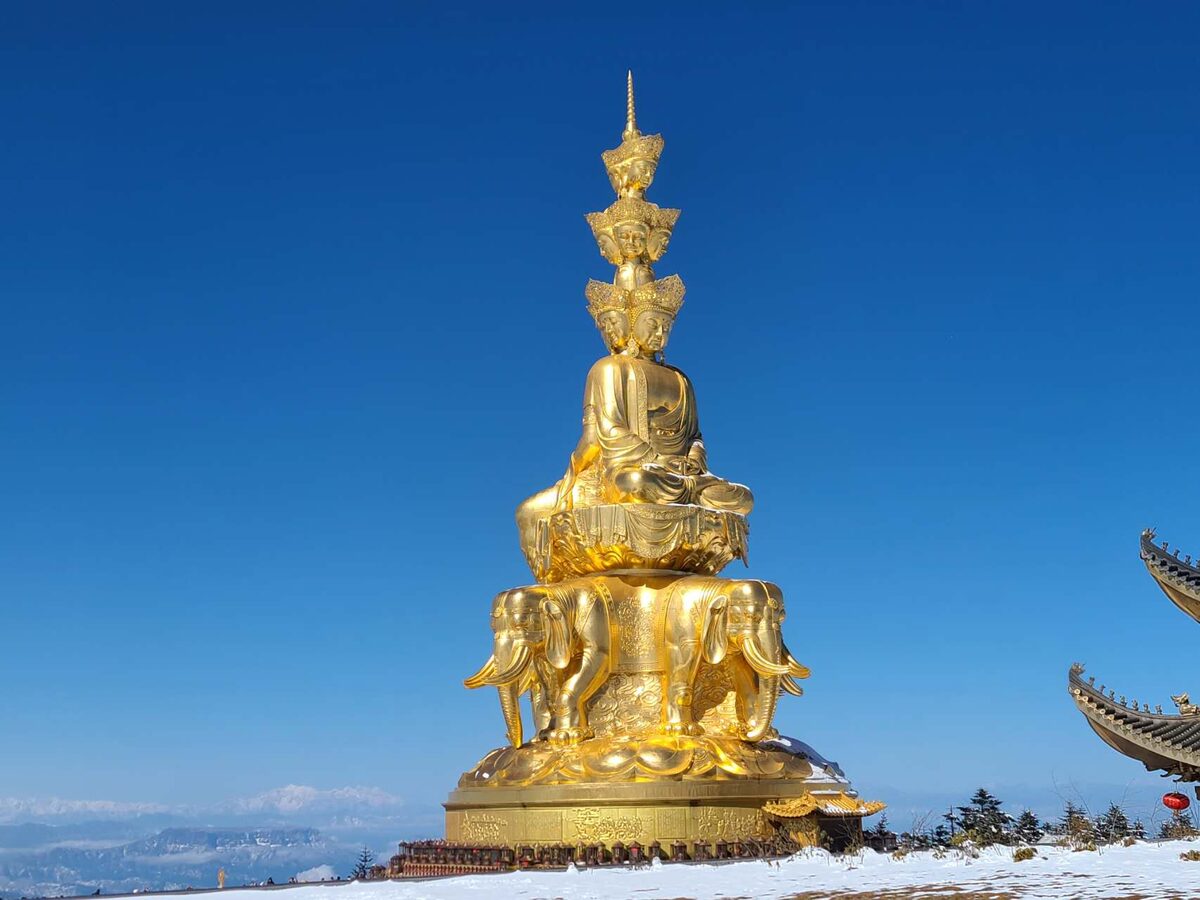 Golden Buddha statue at the Golden Summit of Mount Emei rising above the sea of clouds